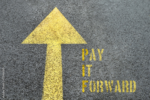 Yellow forward road sign with Pay It Forward word on the asphalt photo