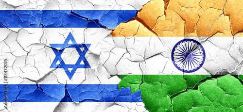 Israel flag with India flag on a grunge cracked wall