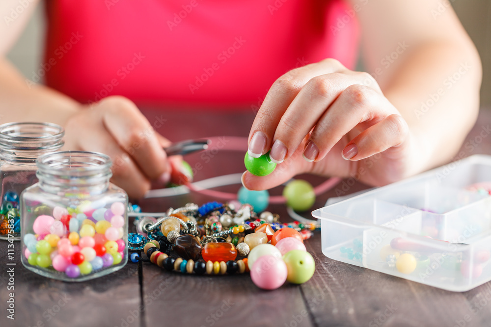 Woman designing colorful necklace with plactic beads Woman designing colorful necklace with plactic beads