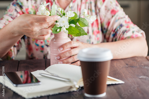 Coffee to go. White flowers on the rustic background.