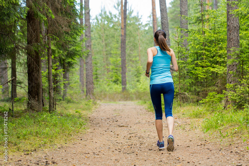 Fototapeta Naklejka Na Ścianę i Meble -  Woman fitness jogging workout in nature, wellness concept.