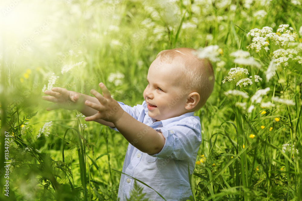 The little boy looks out of the tall grass The little boy looks out of the tall grass