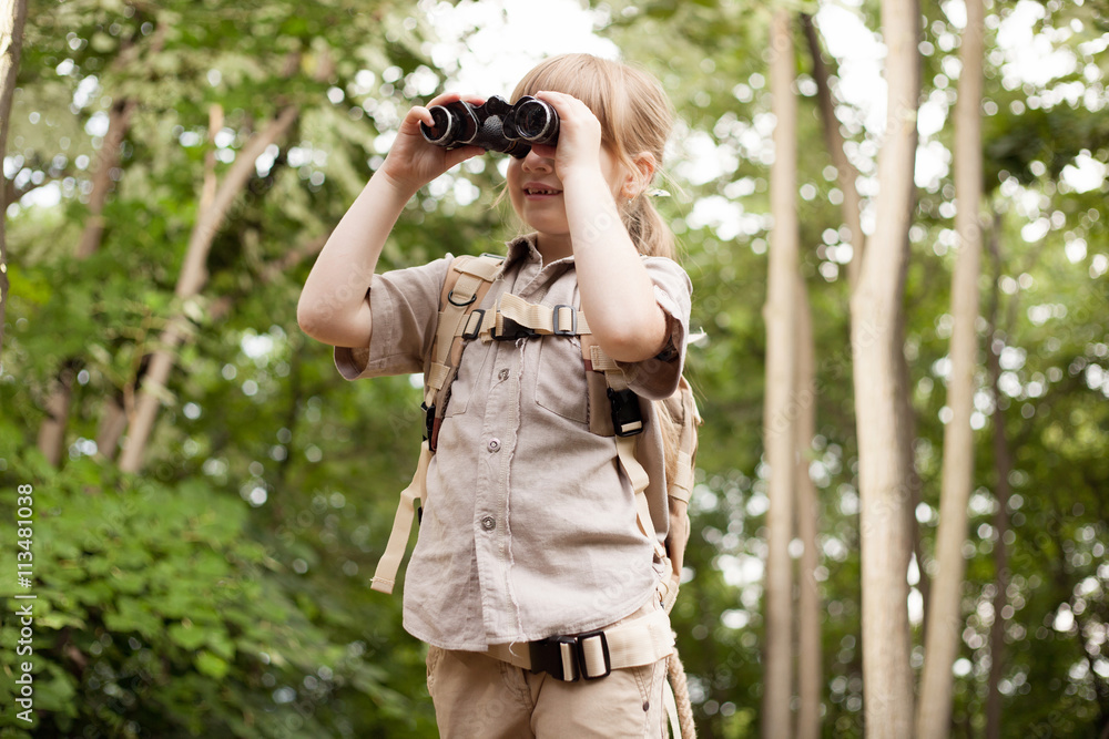 young girl scout, explores nature with binoculars on camping tr young girl scout, explores nature with binoculars on camping tr