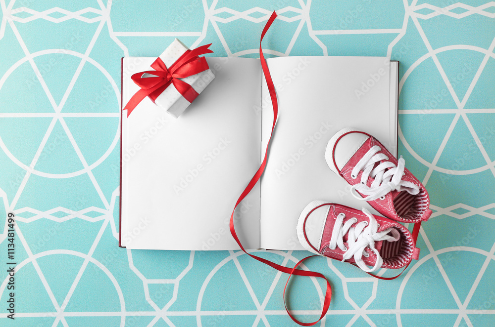 Fototapeta premium Baby boots and notebook , top view