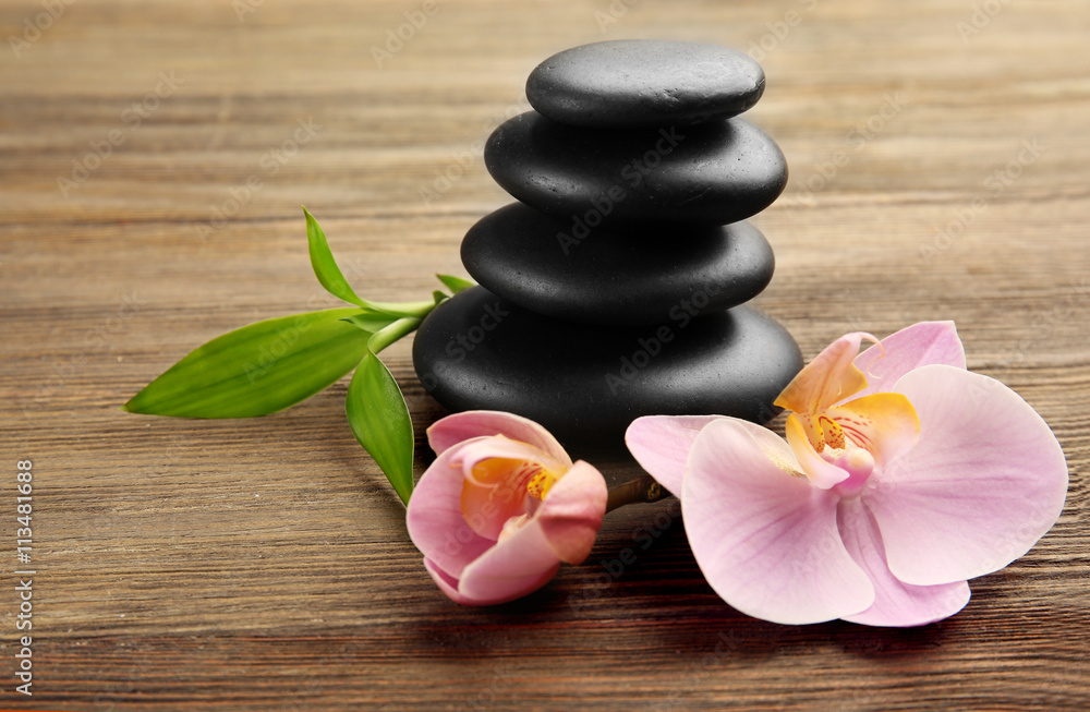 Spa stones and orchid flowers on wooden background Spa stones and orchid flowers on wooden background