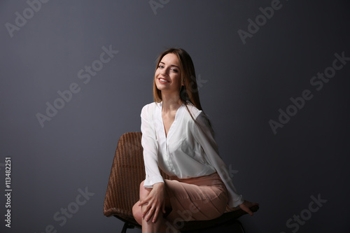 Beautiful young woman sitti...