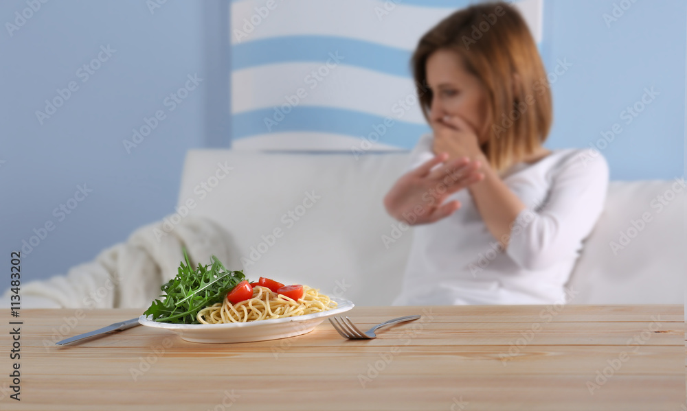 Young depressed girl with eating disorder at wooden table Young depressed girl with eating disorder at wooden table