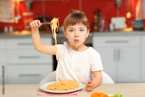 Adorable little girl eating...