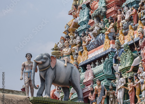 Chettinad, India - October 17, 2013:Detail of the Shiva temple gopuram at Kottaiyur shows Lord Shiva as supreme teacher and elephant walking away. Plenty of colorful statues. photo