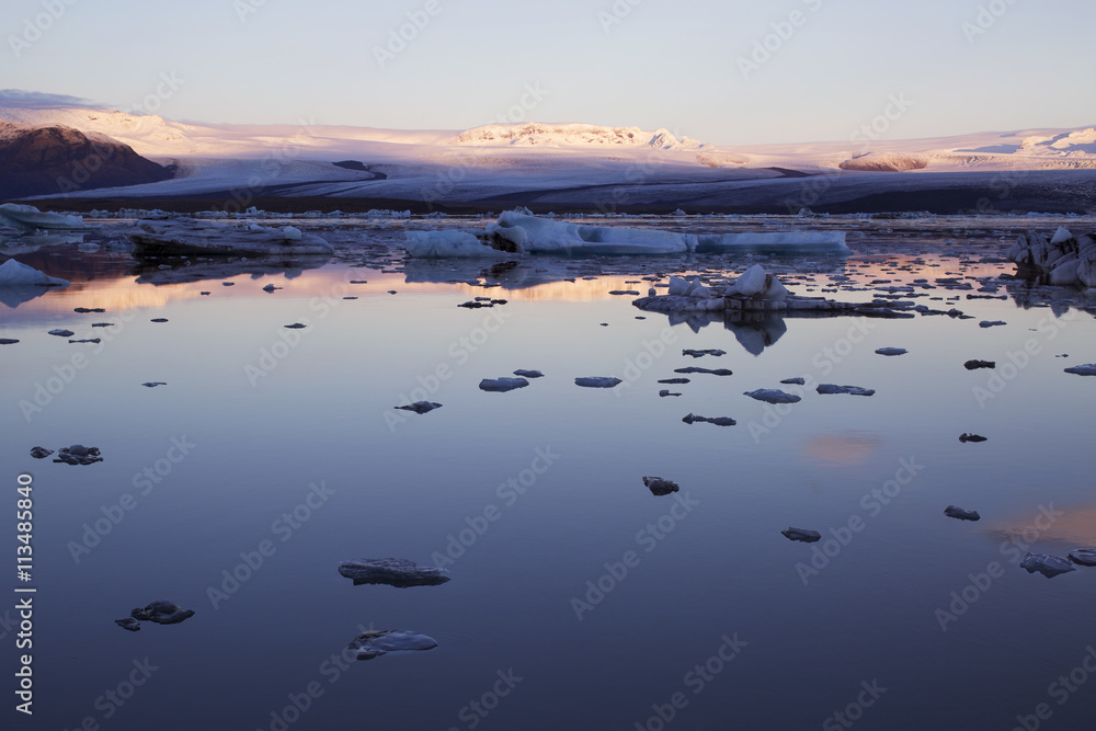 Scenic view of frozen lake by snowcapped mountain during sunset Scenic view of frozen lake by snowcapped mountain during sunset