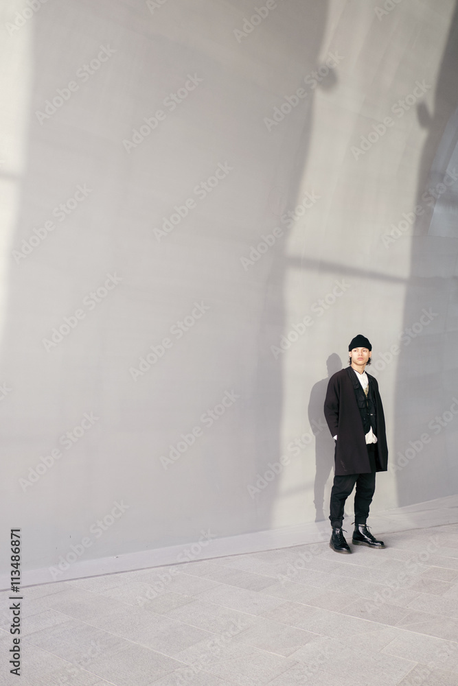 Young man standing against white wall Young man standing against white wall