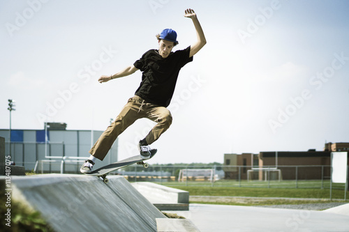 Young man performing stunts on skateboard photo