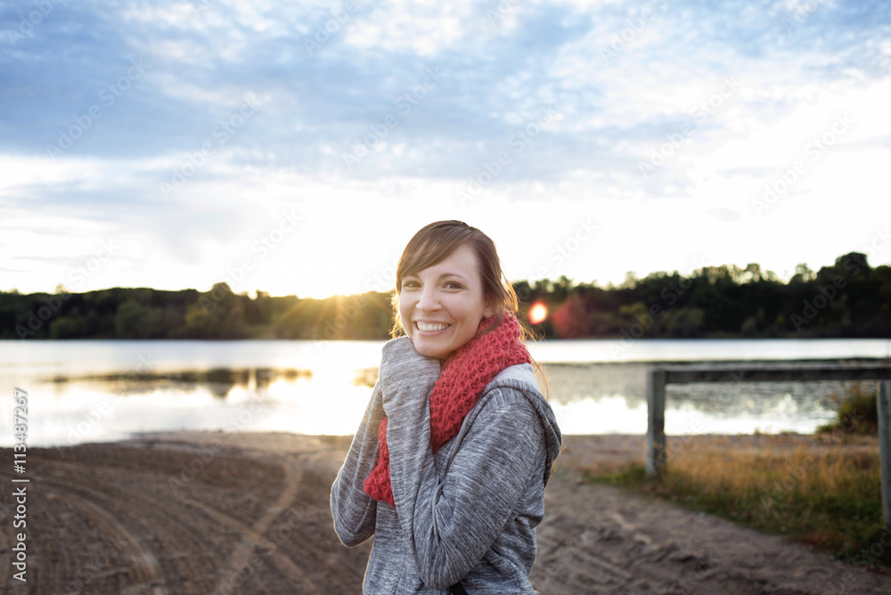 Portrait of happy woman standing at lakeshore on sunny day Portrait of happy woman standing at lakeshore on sunny day