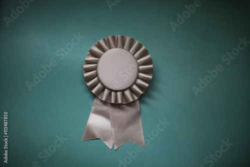 Close-up of award ribbon against green background