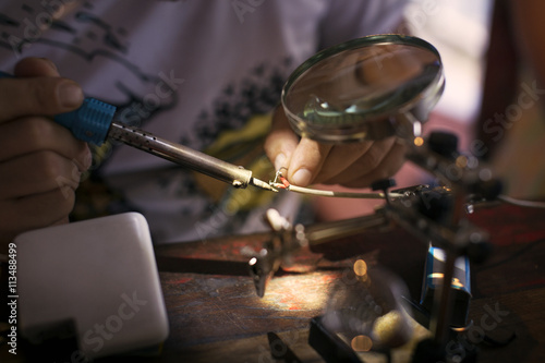 Close up of man's hand soldering electrical wires photo