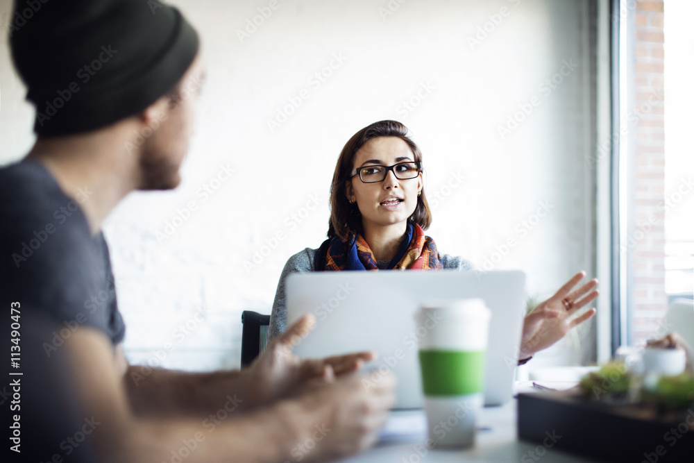 Businesswoman explaining to colleague during meeting in office Businesswoman explaining to colleague during meeting in office
