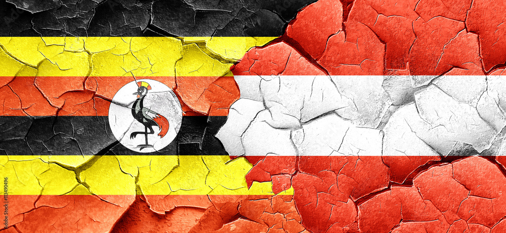 Uganda flag with Austria flag on a grunge cracked wall
