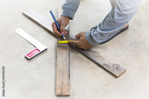 Male carpenter working with wood pencil and tape measure at work place.Background craftsman tool.Zoom in.