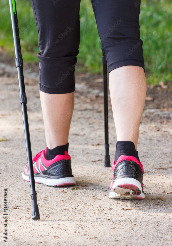 Legs of elderly senior woman practicing nordic walking, sporty lifestyles in old age Legs of elderly senior woman practicing nordic walking, sporty lifestyles in old age