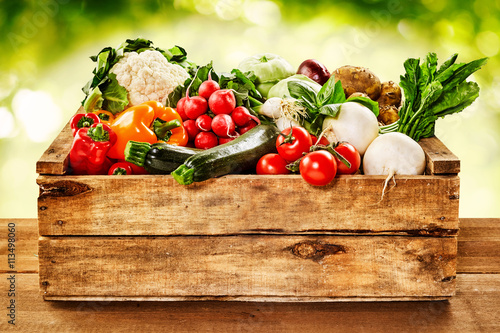 Wooden crate of farm fresh vegetables photo