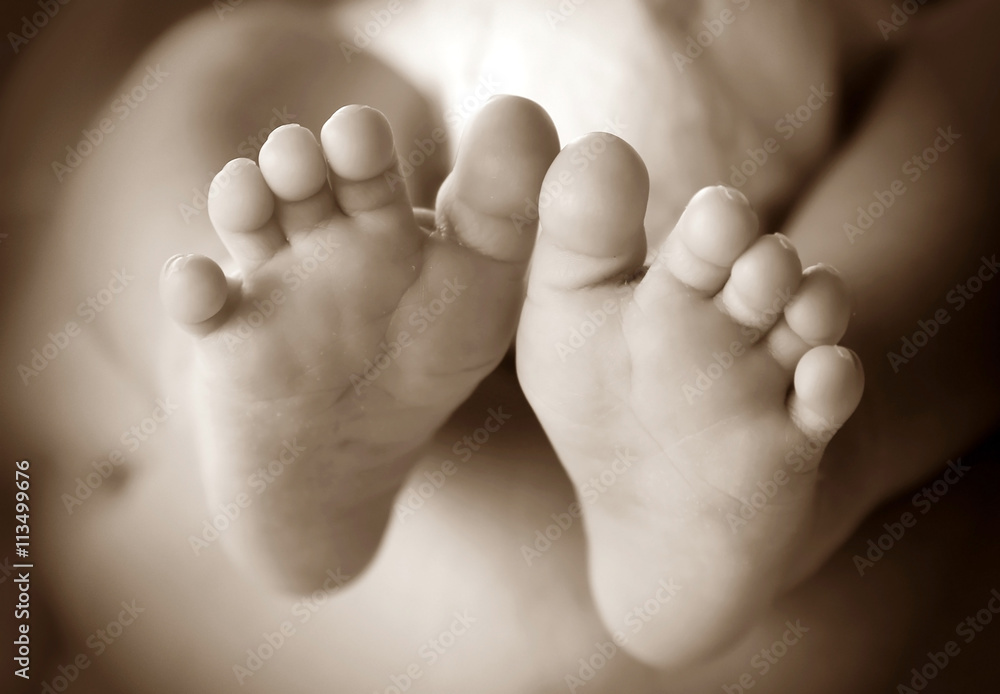 Photo of newborn baby feet in soft focus - sepia Photo of newborn baby feet in soft focus - sepia