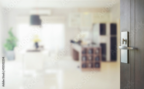 opened wooden door to blurred interior background of modern dining room with pantry. © worldwide_stock