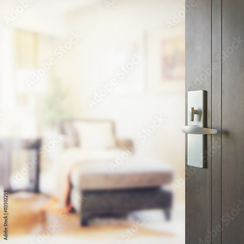 opened wooden door to blurred interior of modern living room © worldwide_stock