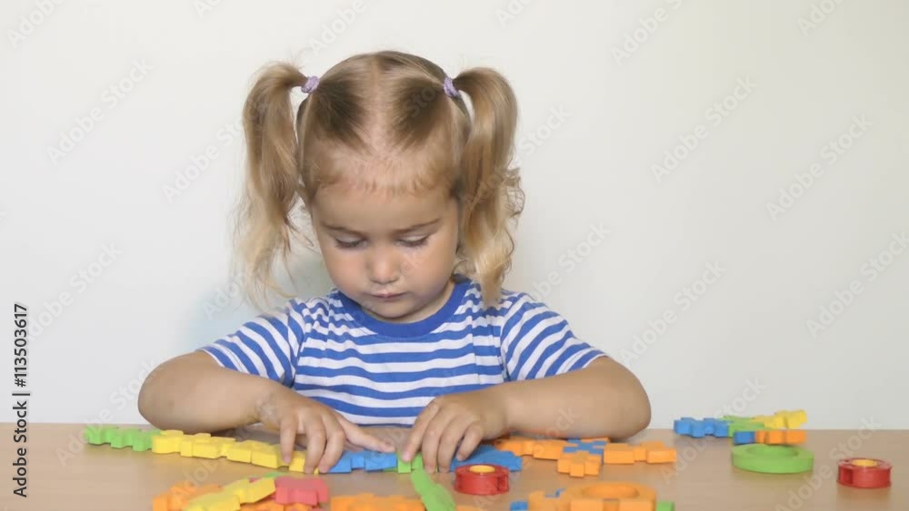 child little girl playing plastic toys at home or kindergarten.children designer.