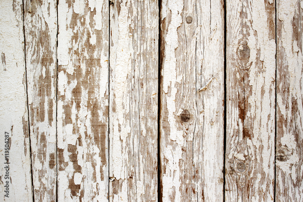 White paint peeling off the wooden wall