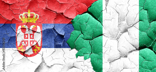 Serbia flag with Nigeria flag on a grunge cracked wall