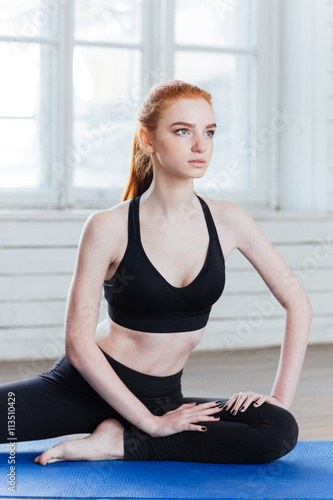 Young fitness woman sitting in yoga position