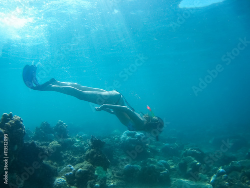 Underwater shot of the woman moving on the breath hold in the depth. Amed village, Bali, Indonesia