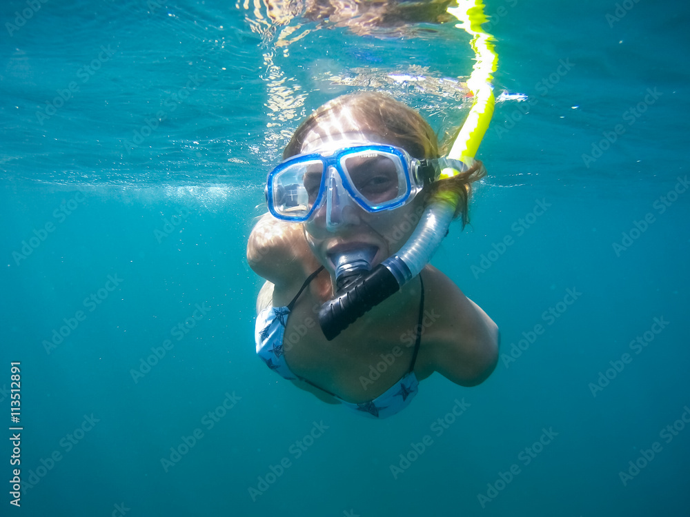 Naklejka premium Underwater shot of the woman moving on the breath hold in the depth. Amed village, Bali, Indonesia