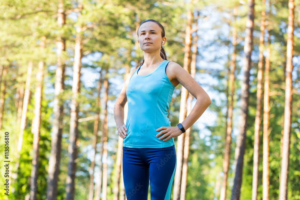 Runner woman with heart rate monitor ready for running in forest Runner woman with heart rate monitor ready for running in forest