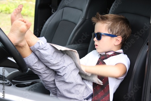 Cute driver reads newspaper in car