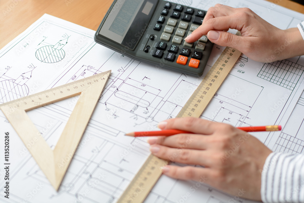 Mechanical engineer at work. Technical drawings. Paper with technical drawings and diagrams.