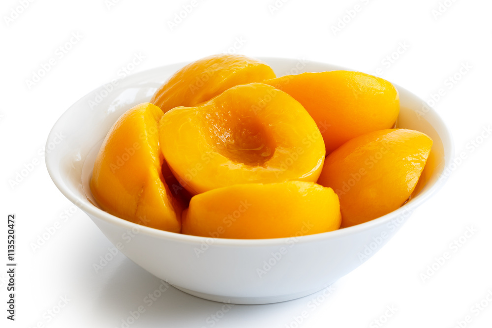 Canned peach halves in bowl isolated on white background. In per Canned peach halves in bowl isolated on white background. In per