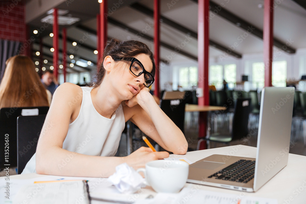Bored businesswoman working using laptop in office Bored businesswoman working using laptop in office