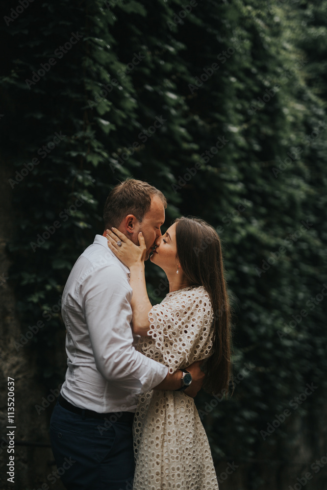 Fototapeta premium Young cute couple honeymoon posing in the street holding their hands on dating in a beautiful place italy near ocean and mountains, hug, smile and talk to each other 
