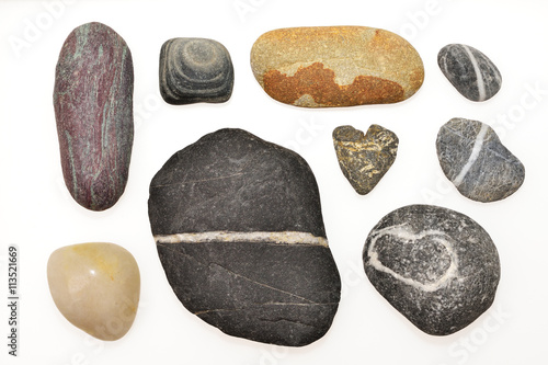 Photos Various pebbles include the heart shape on withe background.