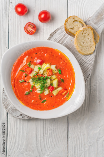 Vegetable soup gazpacho, stand, cherry tomatoes, white bread on