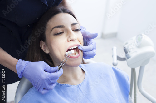 Beautiful woman patient having dental treatment at dentist s office. Woman visiting her dentist