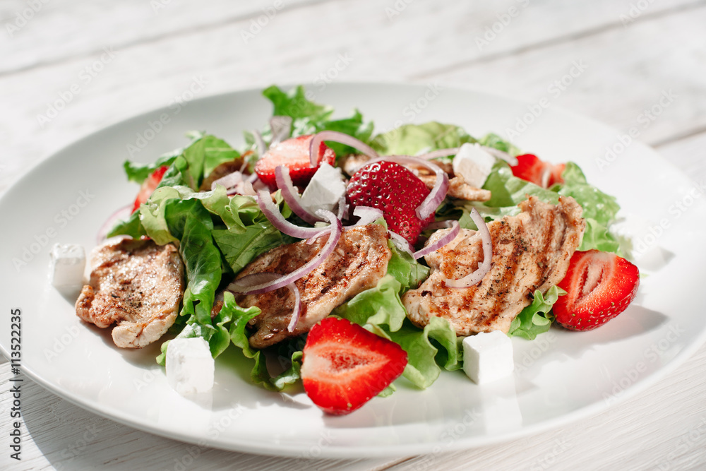 Portion of steaks with strawberry and feta cheese. Front view on white plate with meat steaks with strawberries,greens and feta on white background. Portion of steaks with strawberry and feta cheese. Front view on white plate with meat steaks with strawberries,greens and feta on white background.
