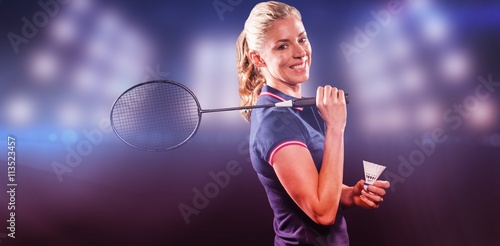 Badminton player holding racket and shuttlecock against composite image of spotlight 