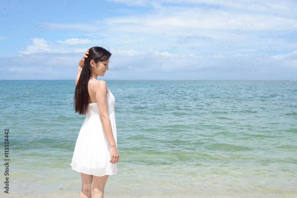 南国沖縄の美しいビーチで寛ぐ女性 