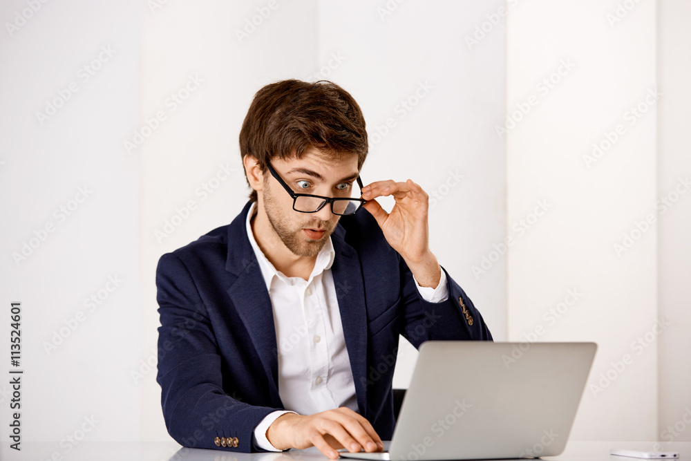 Young businessman sitting at the office desk Young businessman sitting at the office desk