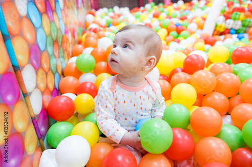 Beautiful baby girl playing with colorful balls © bogonet