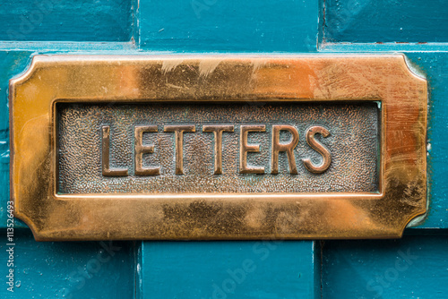 Vintage brass letterbox on blue door background