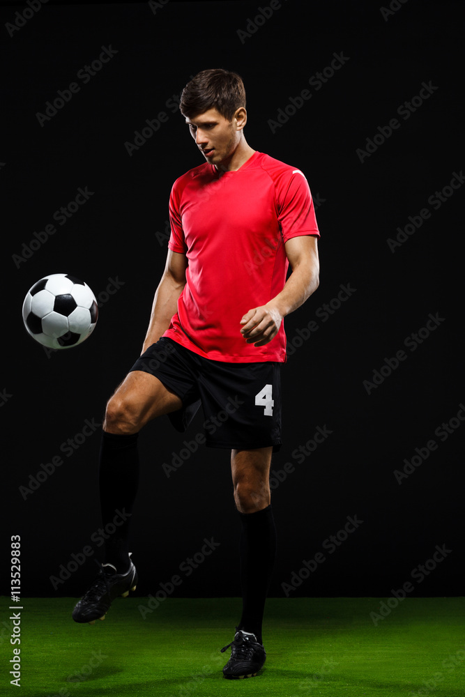 Soccer player kicking ball over black background Soccer player kicking ball over black background