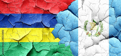 Mauritius flag with Guatemala flag on a grunge cracked wall